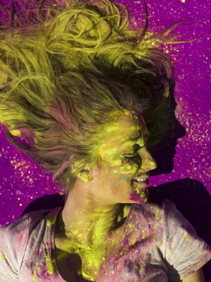 elevated-view-smiling-woman-covered-with-holi-color-powder-scaled